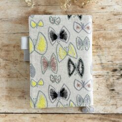 butterfly pattern in vibrant yellow, plus greys and browns, and a pale grey vegan 'leather' trim.