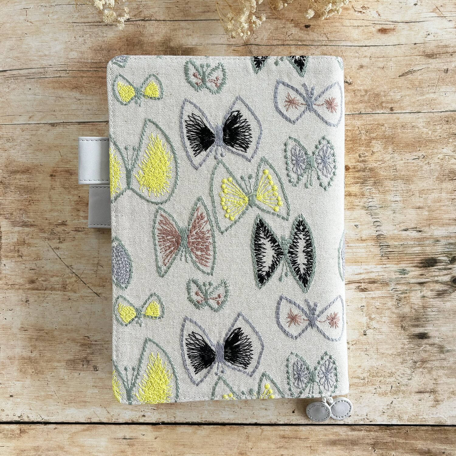 butterfly pattern in vibrant yellow, plus greys and browns, and a pale grey vegan 'leather' trim.