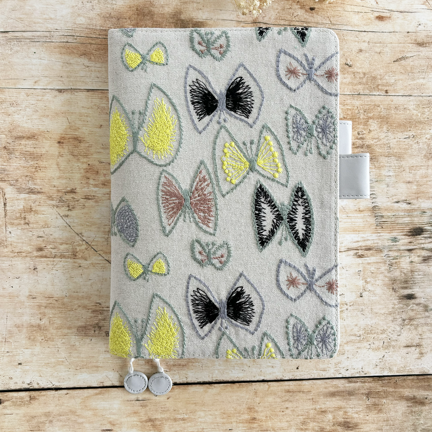 butterfly pattern in vibrant yellow, plus greys and browns, and a pale grey vegan 'leather' trim.