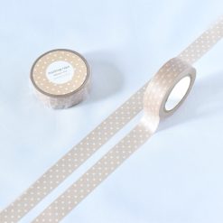 Beige polka dot washi tape by Papier Platz with white dots, shown rolled and unrolled on a white background.