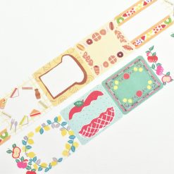 Close-up of Papier Platz PuPuPu sticky roll label strip featuring bread-shaped frame, pastries, and fruit motifs.