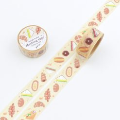 Papier Platz Pupupu washi tape featuring illustrated bakery treats including bread, pastries, sandwiches and donuts on a pale yellow background, shown unrolled alongside the matching roll.
