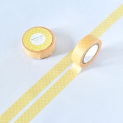 Yellow polka dot washi tape roll with white spots, shown partially unrolled on a white background alongside the matching packaged roll.