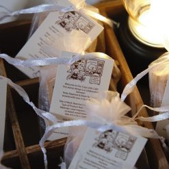 Close-up styled photo of Eileen Tai “Bearista Café Daydream” rubber stamp packaging in organza bags in a wooden tray.