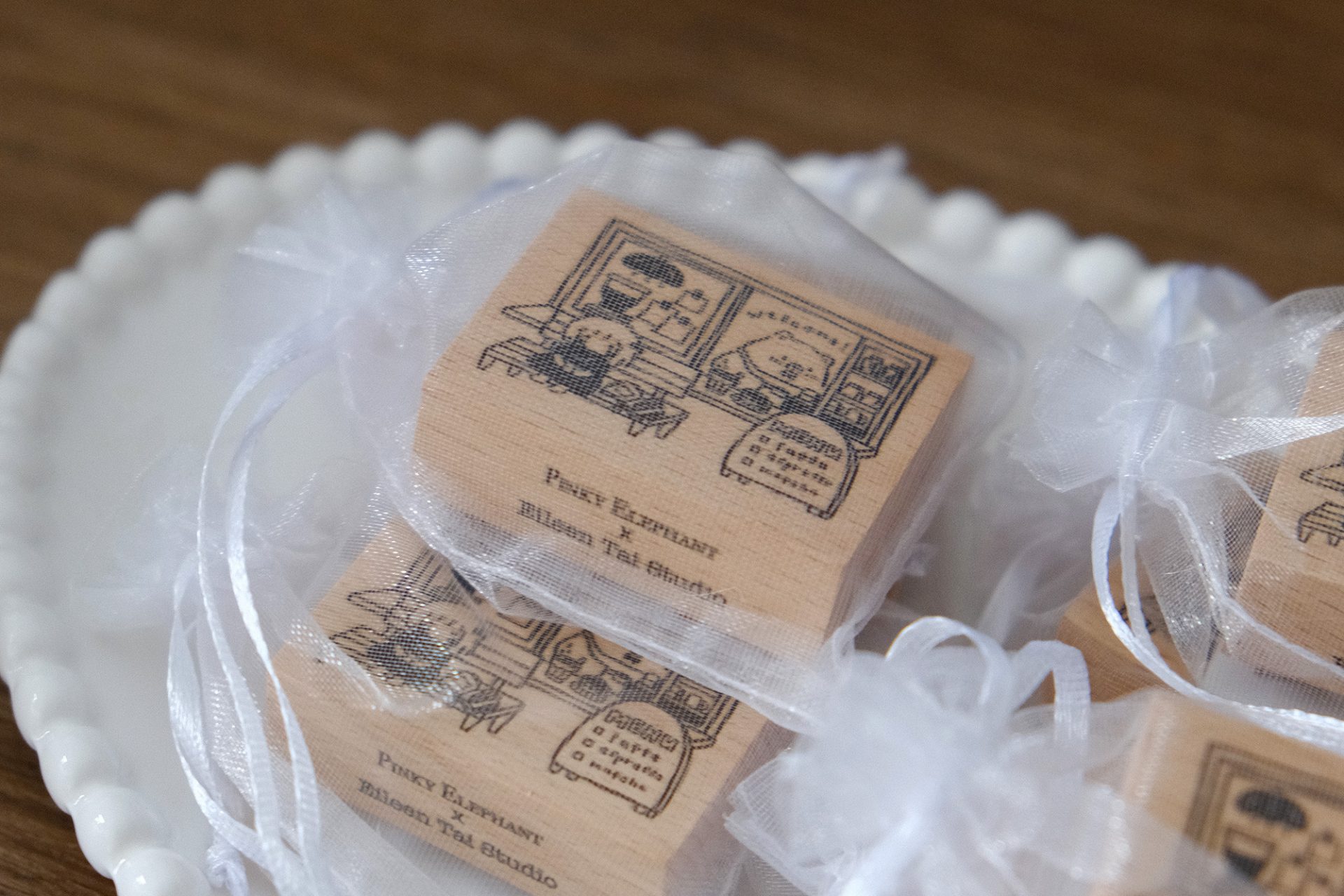 Styled photo of Eileen Tai “Bearista Café Daydream” rubber stamps in organza bags arranged together on a plate.