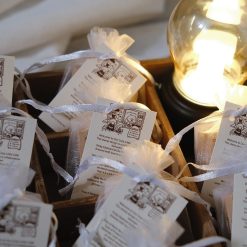 Styled photo of a single Eileen Tai “Bearista Café Daydream” rubber stamp inside an organza bag on a white plate.