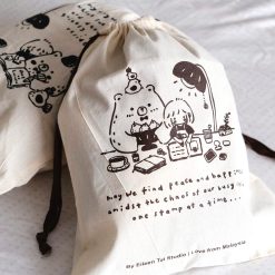 Close-up detail of the illustrated characters printed on an Eileen Tai drawstring pouch.