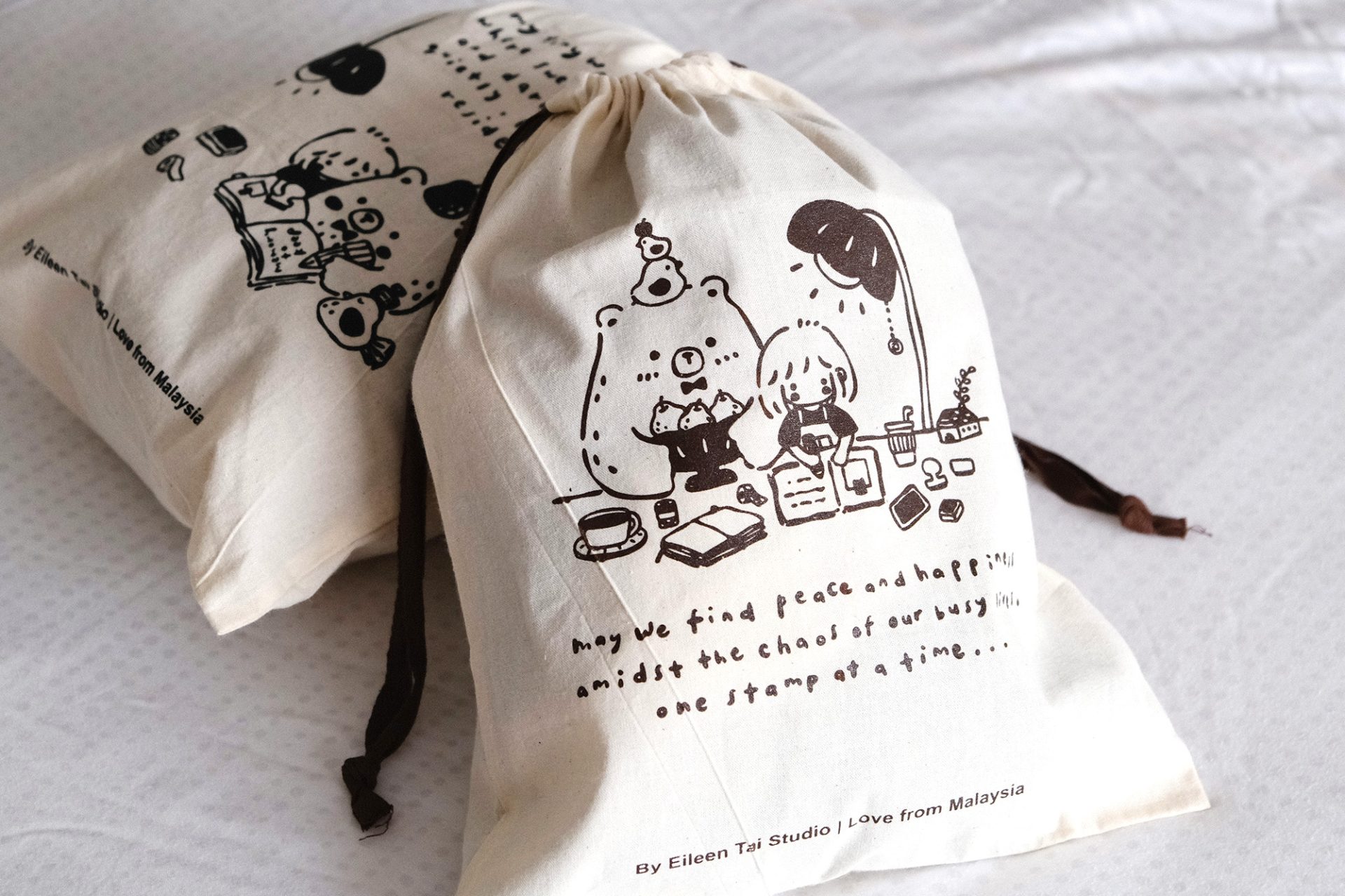 Close-up detail of the illustrated characters printed on an Eileen Tai drawstring pouch.