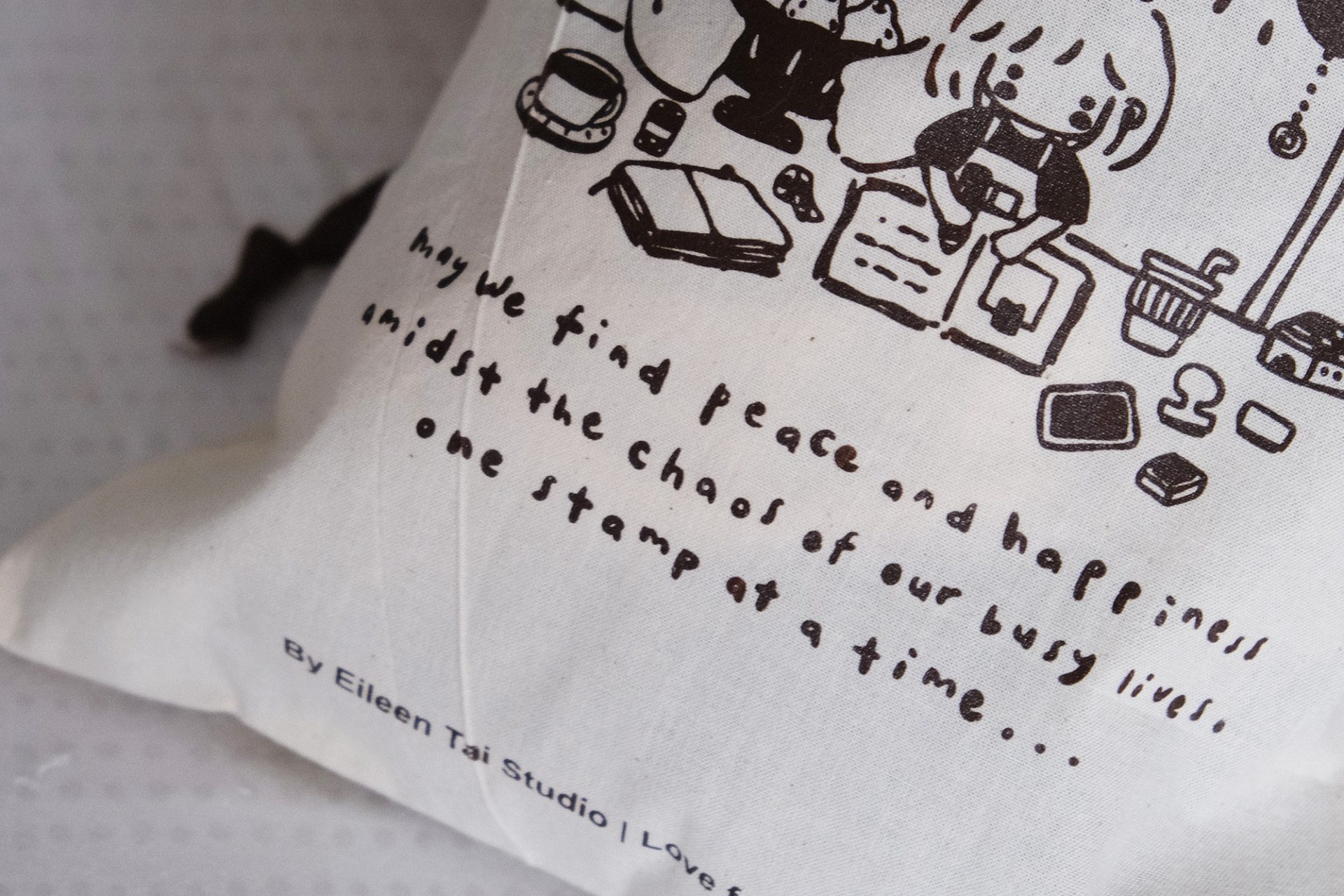 Close-up detail of the branding text on an Eileen Tai drawstring pouch reading “Love from Malaysia”.