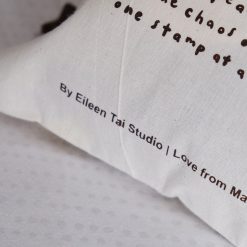 Styled image of several Eileen Tai drawstring pouches with brown drawstrings arranged together.