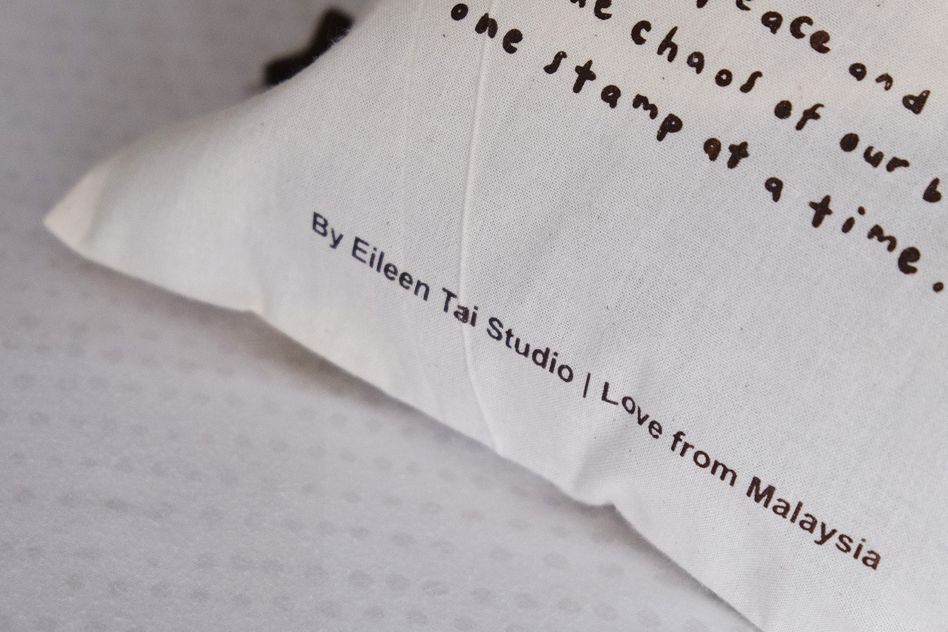 Styled image of several Eileen Tai drawstring pouches with brown drawstrings arranged together.