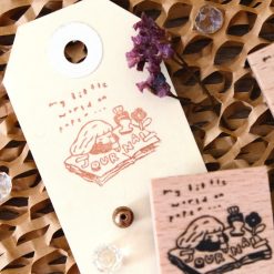 Flat lay of multiple Eileen Tai journal girl wooden rubber stamps arranged on a ceramic plate.