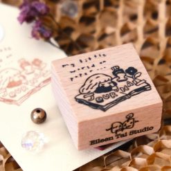 Styled image of an Eileen Tai journal girl rubber stamp with a stamped paper tag.
