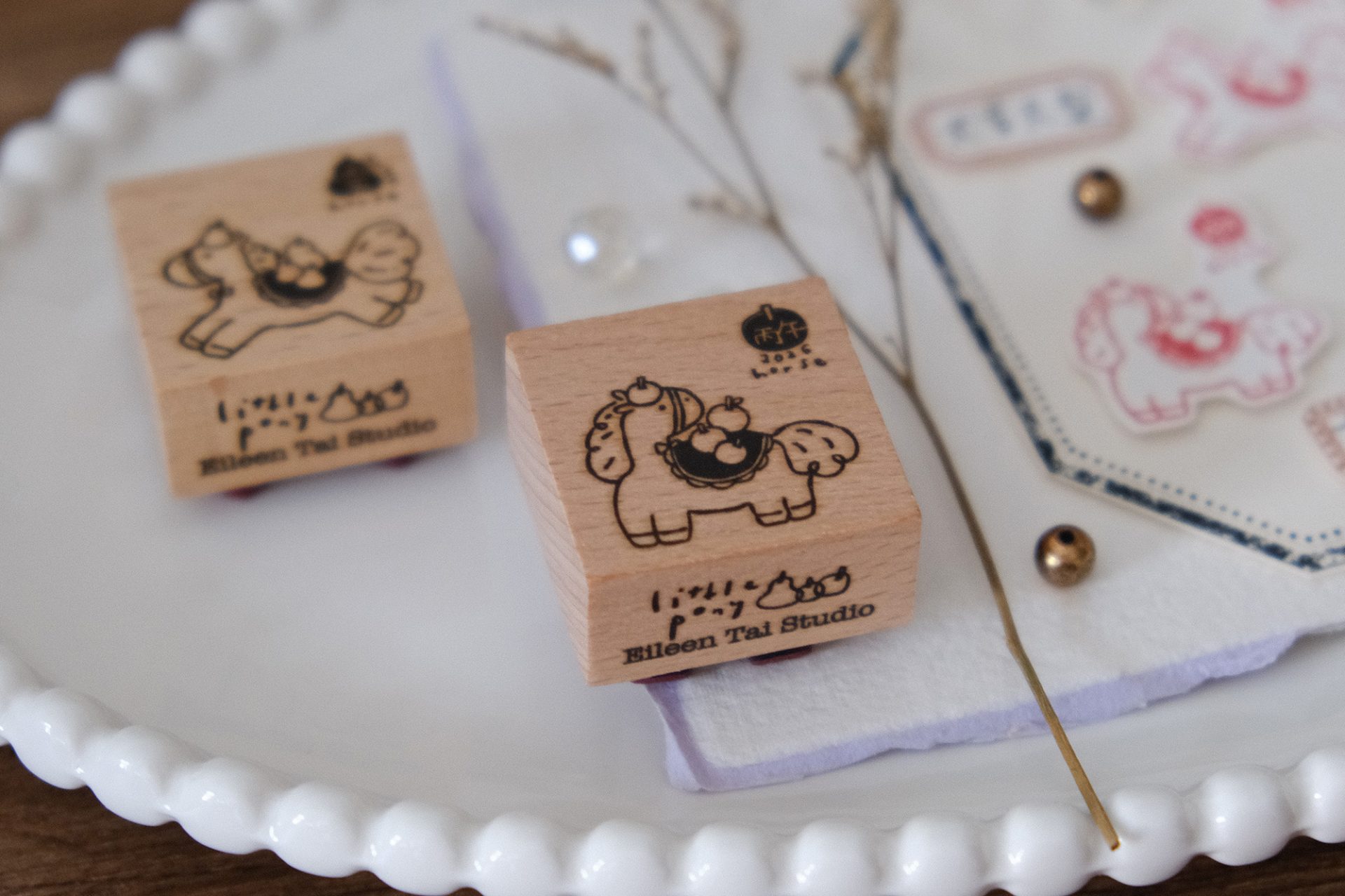 Styled view of Eileen Tai Year of the Horse rubber stamps with apple-themed horse illustrations and stamped details.