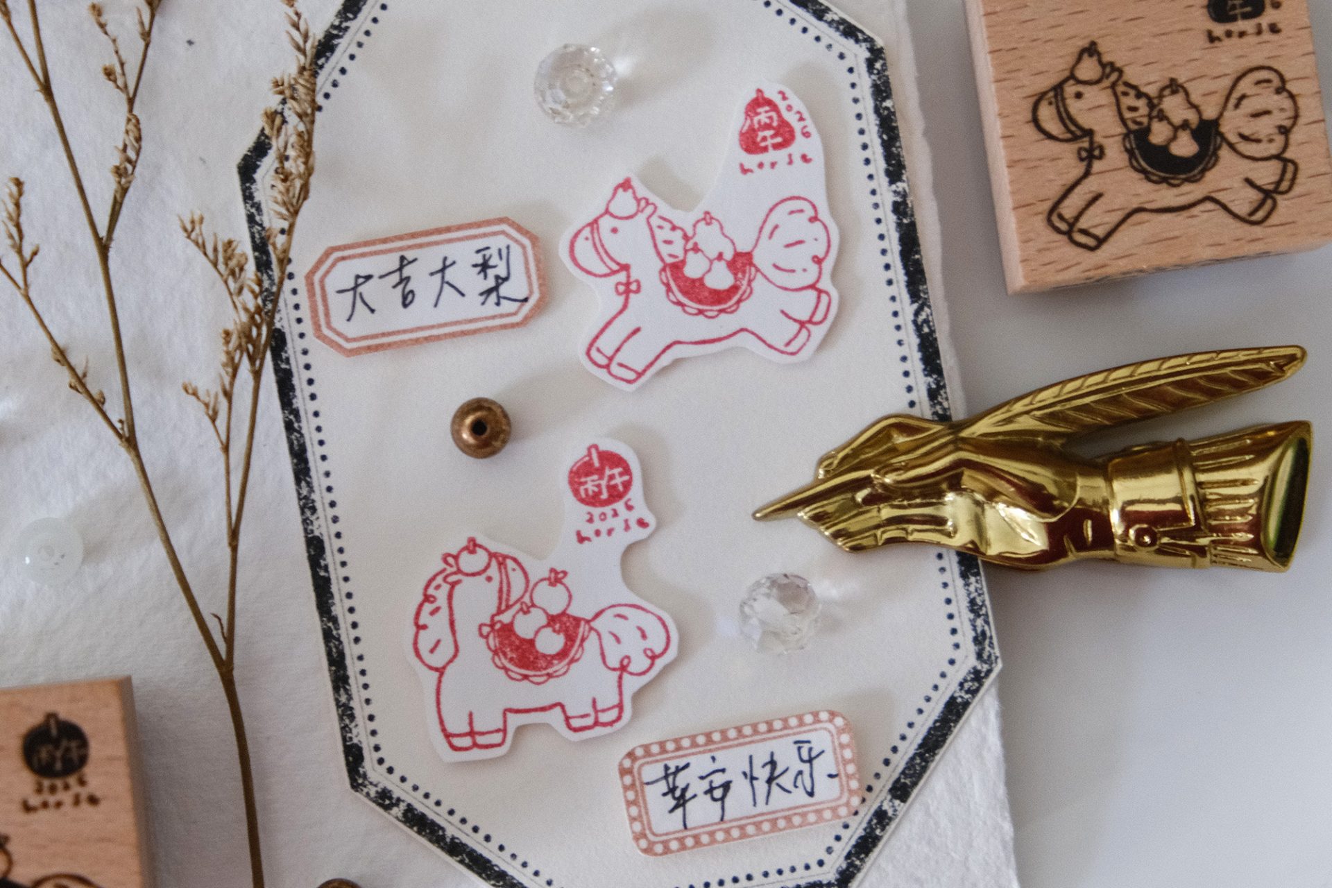 Flat lay of Eileen Tai Year of the Horse wooden rubber stamp with stamped horse illustrations and decorative stationery accessories.