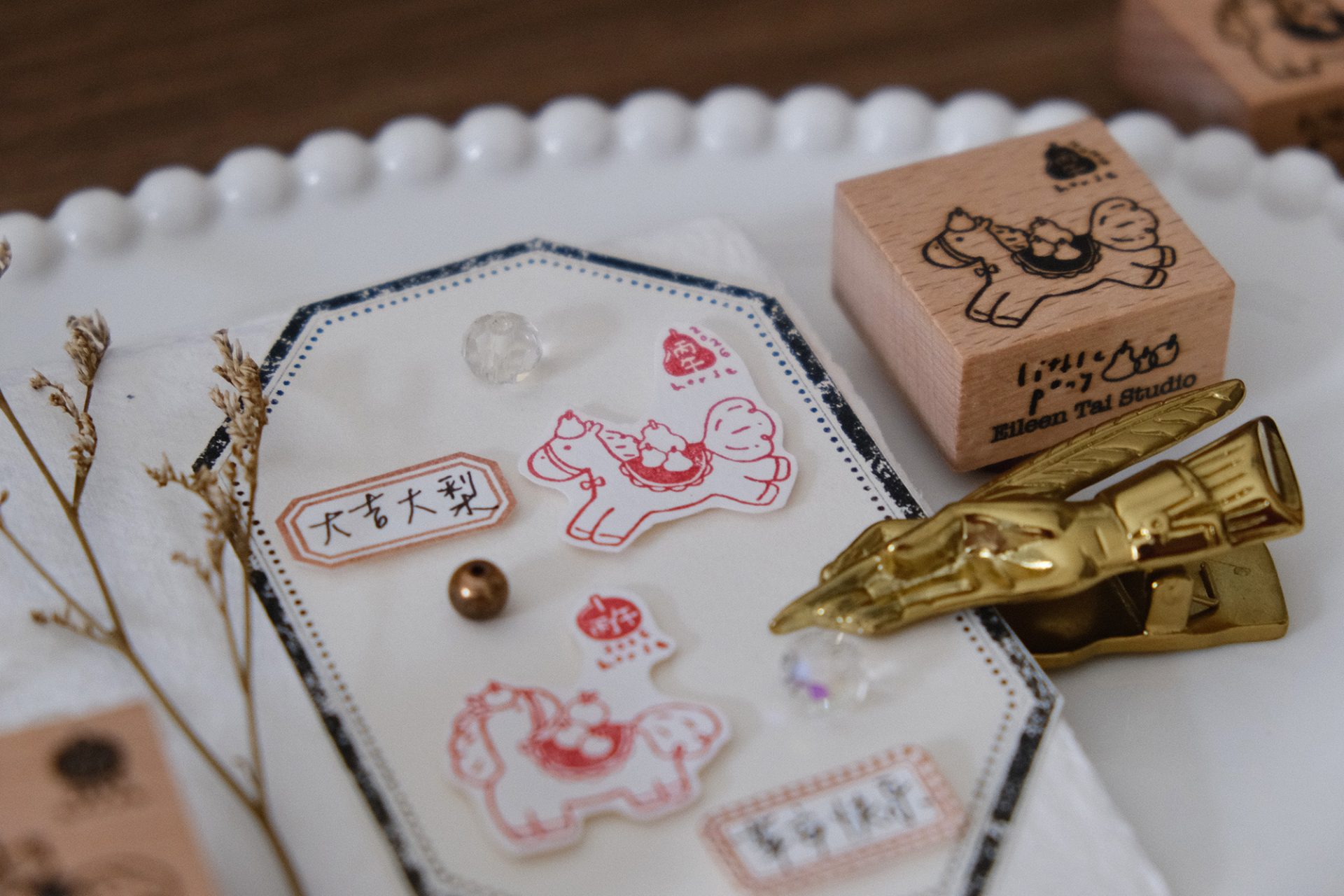 Angled close-up of the Eileen Tai Year of the Horse rubber stamp with pear-themed stamped illustrations.