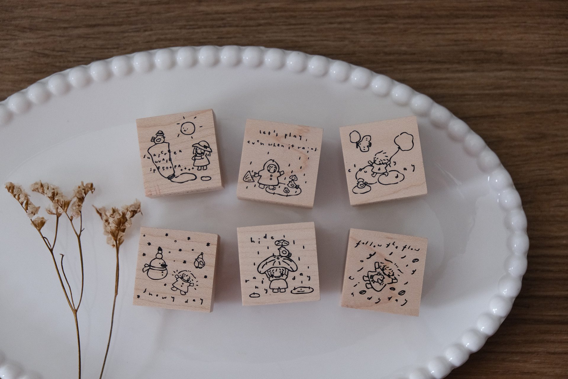 Full Let’s Play weather-themed wooden stamp set arranged together on a ceramic plate.