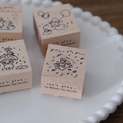 Wooden rubber stamp showing a windy day scene with a child and floating clouds.