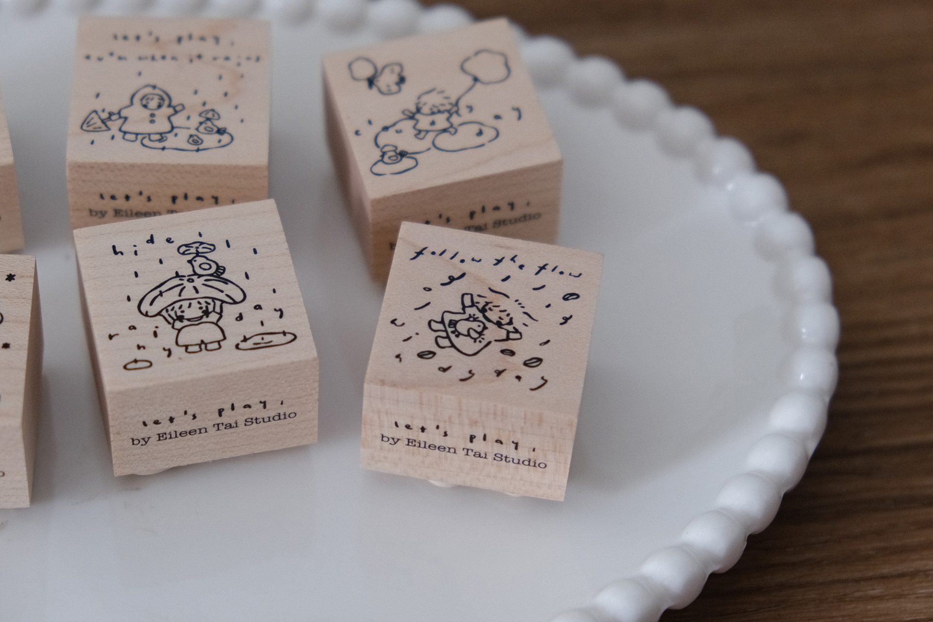 Wooden rubber stamp showing a windy day scene with a child and floating clouds.