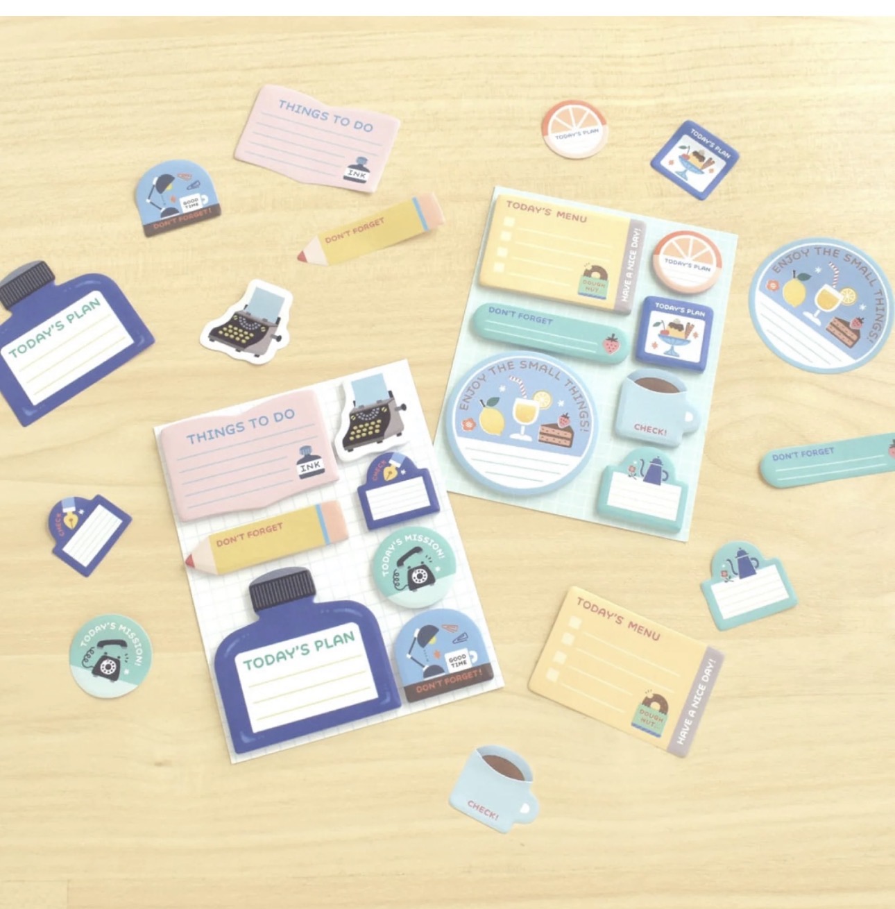 Papier Platz mini sticky notes from the Eric Small Things stationery collection laid out flat showing all small sticky note shapes and designs on a light wood background.