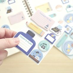 Papier Platz mini sticky notes by Eric Small Things shown in blue-themed packaging with stationery illustrations, photographed on a light wood surface.