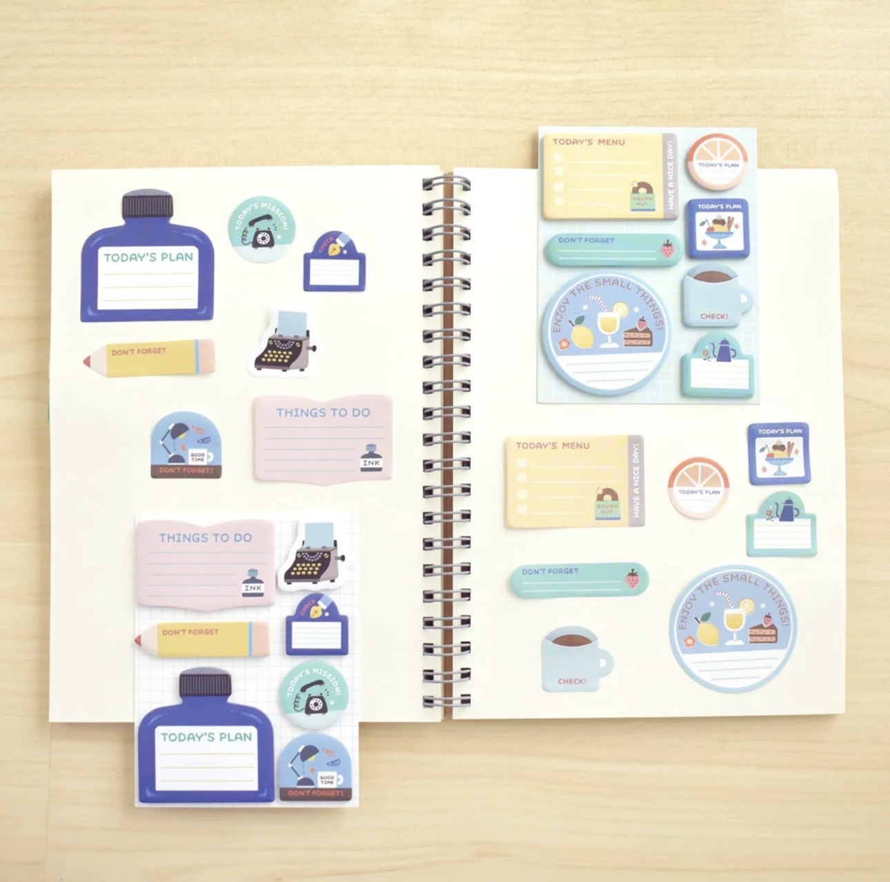 Papier Platz mini sticky notes from the Eric Small Things stationery collection laid out flat showing all small sticky note shapes and designs on a light wood background.