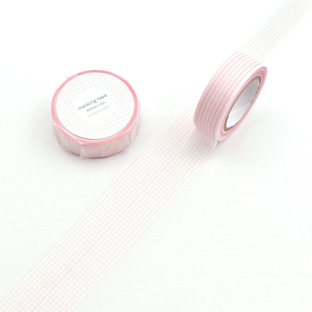 Pink Papier Platz grid masking tape roll with fine grid pattern unrolled on a white background.