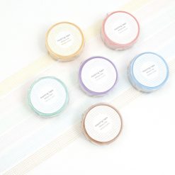Papier Platz grid masking tape rolls in multiple pastel colours arranged on a white background with unrolled tape strips.